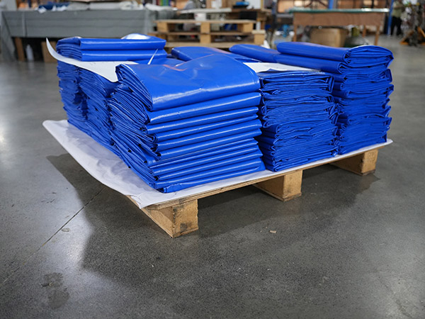 DERFLEX blue PVC coated polyester industrial tarpaulins stacked on a pallet