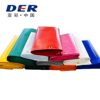 DERFLEX finished tarpaulin samples in several colors with visible reinforced eyelet edges