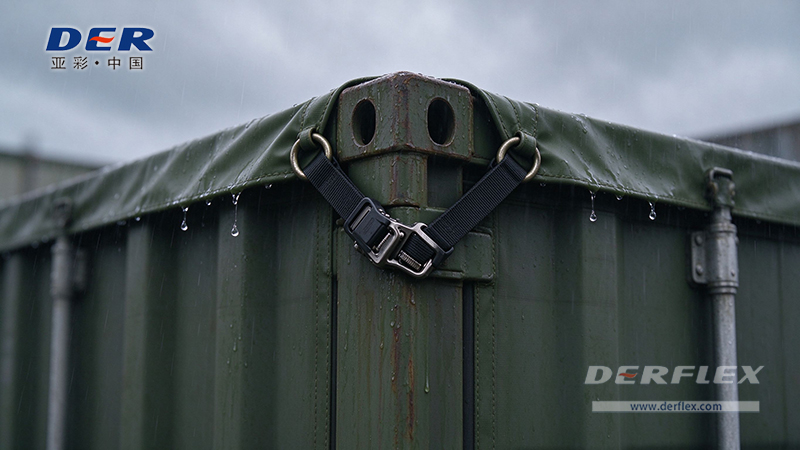 Close view of a PVC container cover at a steel corner casting, secured with webbing and a buckle