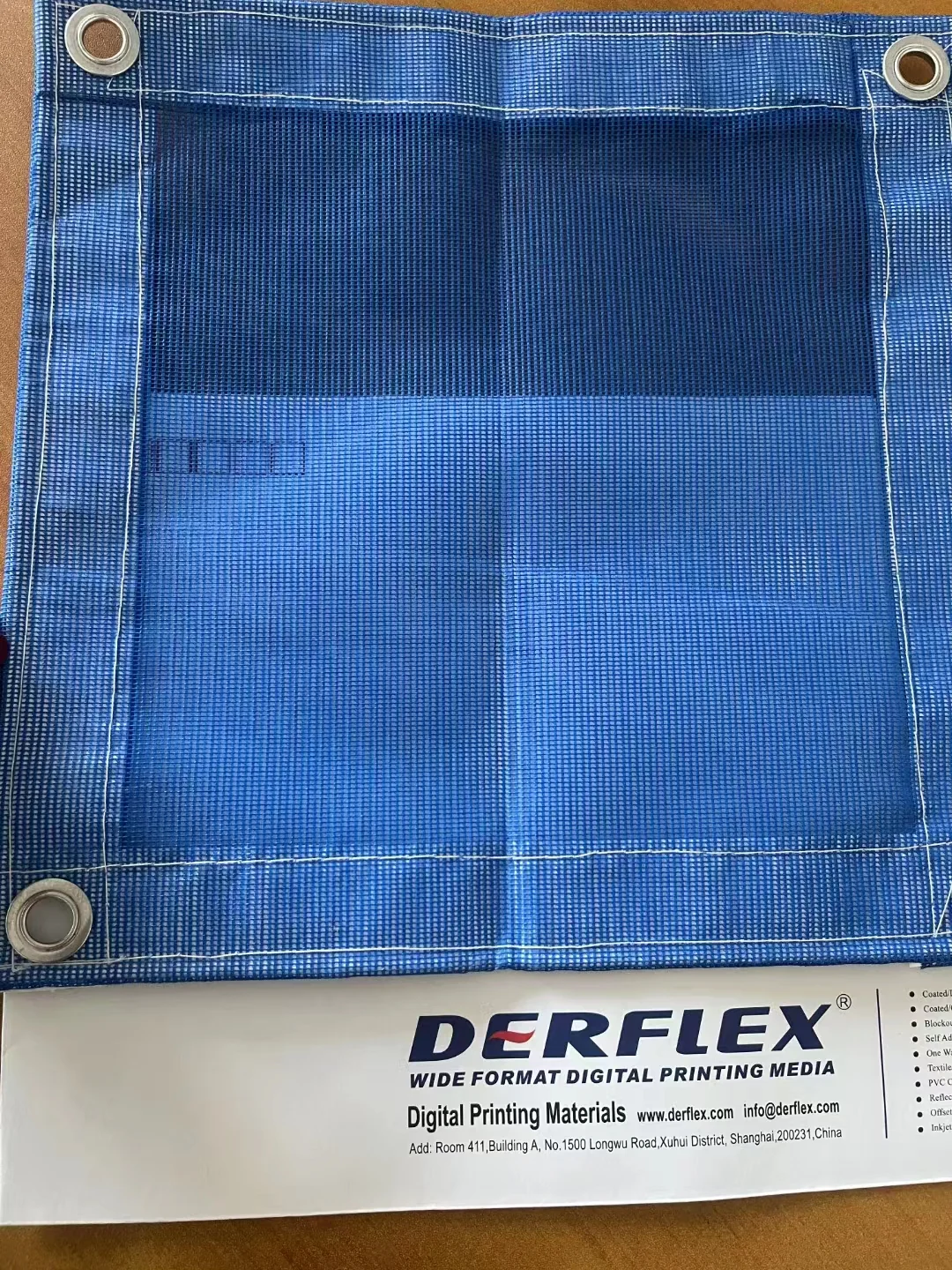 Blue DERFLEX mesh sample with stitched perimeter and metal eyelets