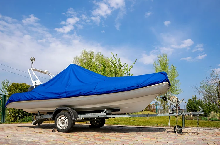 Blue cover on a white boat resting on a trailer