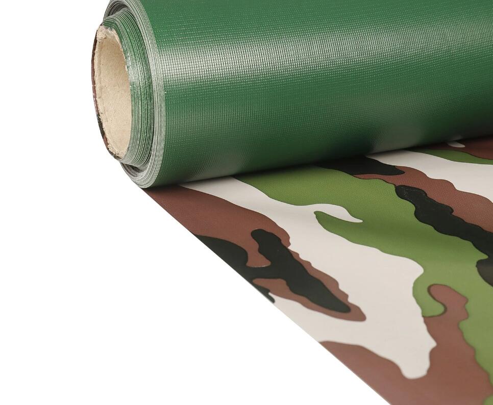 Camouflage-patterned fabric unrolled beneath a green reverse-side fabric roll