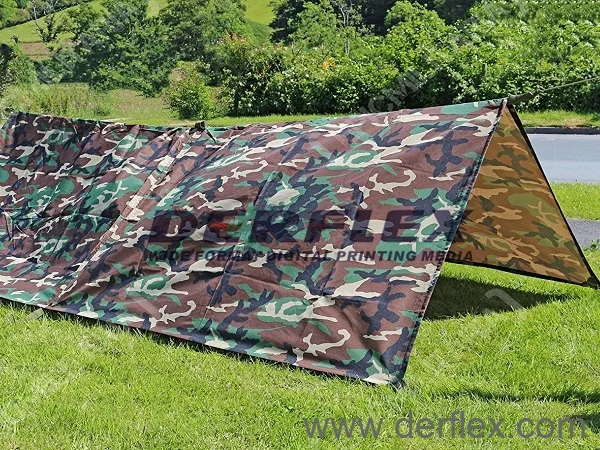 Camouflage tarp pitched as an open-sided shelter on grass