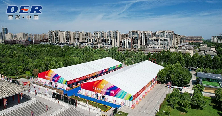Two white event marquees with printed exterior panels in an outdoor exhibition area