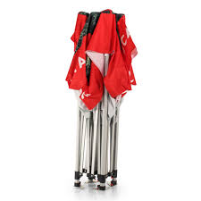Collapsed metal canopy frame with a red fabric roof gathered around its top