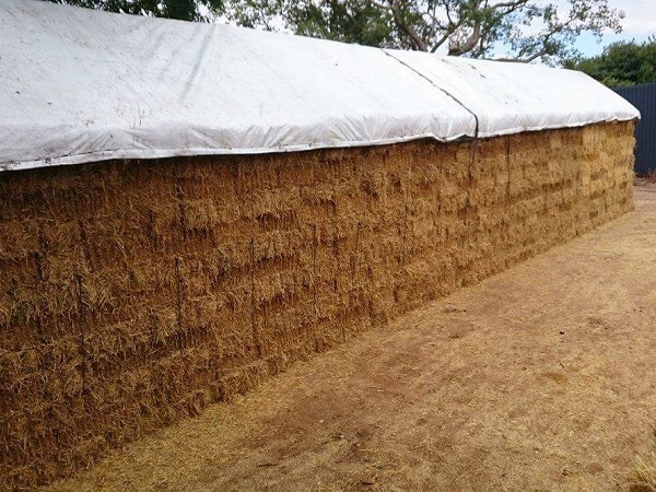 White tarp protecting hay and animal feed storage
