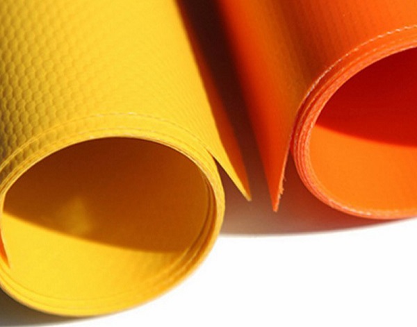 Yellow and orange coated fabric samples curled into rolls