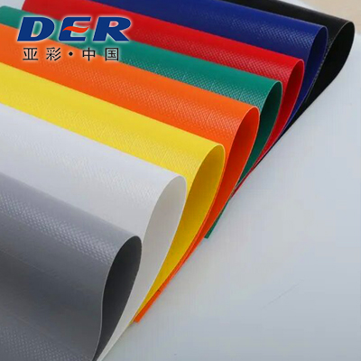 Colored PVC-coated tarpaulin fabric sheets showing their textured surfaces