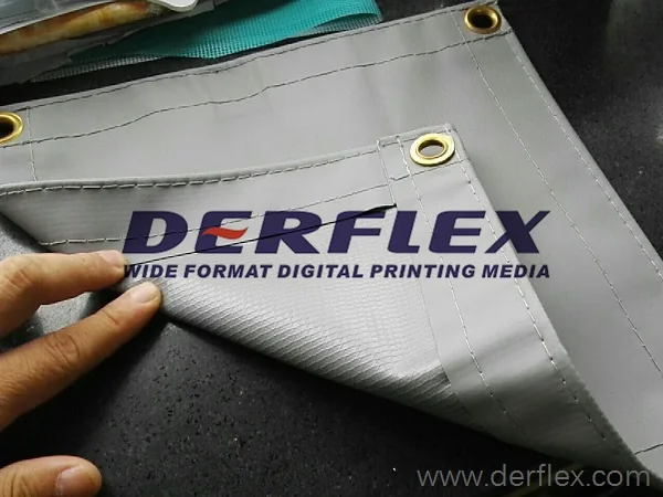 Grey solid vinyl tarp sample showing reinforced corners and eyelets