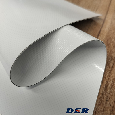 White coated textile sample curled to show its textured surface and cut edge